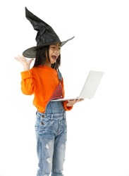 Cutout isolated studio shot of Asian young cute girl in casual orange party costume with black witch hat standing holding hand up say hi greeting on video call via laptop computer on white background.