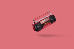 Vintage radio cassette recorder isolated over pink background. Old retro red radio and cassette player. retro technology