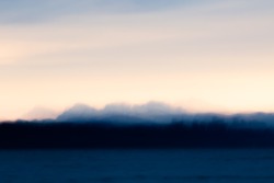 An impressionist photograph of the Cheam Mountain Range as seen from Boundary Bay British Columbia at Sunrise. Taken using the ICM (intentional camera movement) technique.