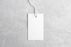 Rectangle white tag mockup with white cord, close up. Blank paper rectangular price tag mockup isolated on grey background with copy space, Sale and Black Friday concept