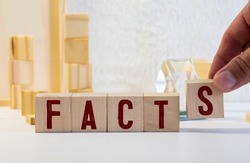 Facts symbol. The concept word 'facts' on wooden cubes. Beautiful white table, white background, copy space. Business, fact and facts concept.