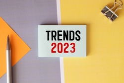 Text TRENDS 2023 on white paper between white and brown spiral notepads.