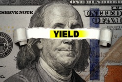 Torn bills revealing YIELD words. Ideas for US Dividend yield, stocks and funds, Passive income, US dollar ETF, Investing for incomes, Dividend calculator, Buy and Hold, Stable income, Finance concept