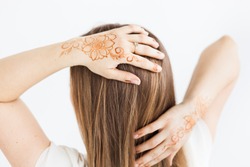 Girl's hands on white background with henna pattern, Indian patterns. Body decoration