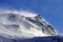 strong south wind in the alps in winter on a sunny day in the national park hohe tauern in austria