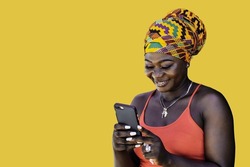 Ghana woman with African colorful headdress standing and chatting with mobile phone, illustrating the wireless technology in today's society