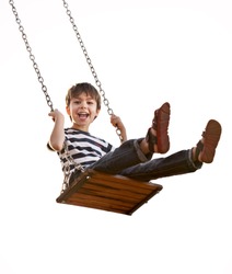 Cute boy playing on swing, having fun.  On a white background.