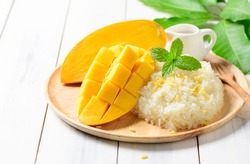 Ripe mango and sticky rice with coconut milk on white wood background, Thai dessert on summer season