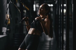 Fit young woman at a crossfit style on dark gray background. Fitness, functional, training, and lifestyle concept