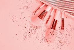Color of the year 2019 Living Coral. Set of makeup brushes on Living Coral colored composed background. Top view point, flat lay.