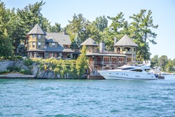 One Island with the white house with a white boat  in Thousand Islands Region in summer in Kingston, Ontario, Canada