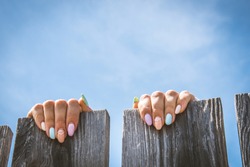 Female fingers on the fence. Isolated female hands