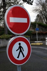 French road signs indicating a prohibited direction and a passage prohibited for pedestrians
