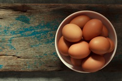 An image top view or flat lay egg easter heaped in a cup is a fresh treat for farm chicken with background copy space for text.