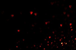 Red hearts, blurred bokeh lights on black background. Glitter sparkle for valentines day. Overlay for your design