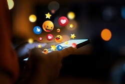 Woman using smartphone at night and social 3D graphics icon on screen with beautiful bokeh. girl's hand using a smartphone social icons on smartphone screen
