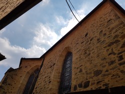 TRADITIONAL BRICK WALL CHURCH IN FRONT OF RED ROOF AND BLUE SKY