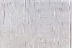 Texture of wet white folded paper on an outdoor poster wall, crumpled paper background.
