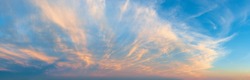 Majestic vanilla sky at evening. Azure sunset heaven with golden pink cirrus clouds over the horizon. Panoramic shot of pastel colored skyscape. Beauty in nature.