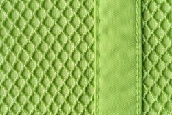 Background of textile mesh over cotton jersey. Macro. Texture of light green knitted fabric with mesh for outerwear casual clothing. Modern sportswear in bright colors concept. Copy space.