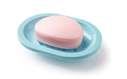 Pink soap bar in a teal blue dish isolated on a white background. Oval shaped bar of soap on a plastic holder for bathroom and shower. Purity, toiletries and washing hands concepts. Top view.