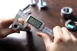 Worker is measuring to the diameter of the small pipe with a digital vernier caliper micrometer. Micrometer, sometimes known as a micrometer screw gauge, is a device incorporating a calibrated screw.