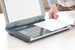 A scanner for copying paper files.The person copies the files on the scanner.