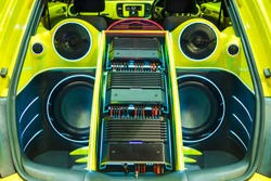 A powerful audio system with amplifiers speakers and lcd monitors in the car trunk.