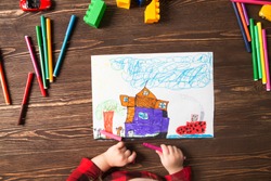 Kids drawing and a lot of painting tools  on a wooden background