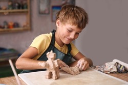 Kid sculpts clay crafts pottery school.