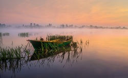 Boat on the lake in the rays of the rising sun and fog, zemborzycki lake