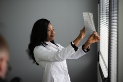 healthcare, medical and radiology concept - african doctor looking at x-rays