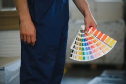 Funny portrait of typographer standing with color swatches at the printing manufacturing.