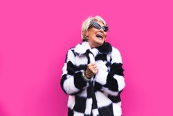Happy and playful senior woman having fun - Portrait of a beautiful lady above 70 years old with stylish clothes, concepts about senior people