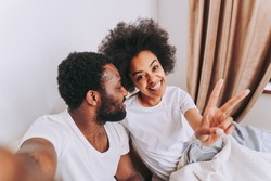 African american couple in bed - Real beautiful and cheerful pair of lovers at home