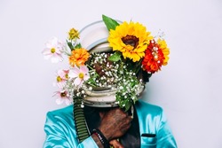 fine art concept with man wearing a space helmet and flowers composition