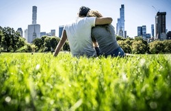 Couple spending time in central park. Young man and woman relaxing and watching the new york skyline