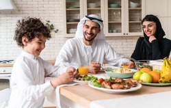 happy family from arab united emirates eating together and celebrating the national day holidays