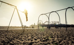 santa monica beach. silhouette of a woman going up with the swing. concept about traveling,united states and people