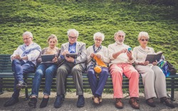 Group of senior people resting in a park - Mature friends doing some activities in a retirement home