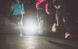 Three women running in the night in the city center