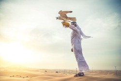 Arabian man walking  in the desert at sunrise