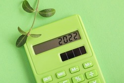 Plans for 2022 written on green calculator. Fresh Plant, Green calculator on green background. Environmental, Social, Corporate Governance.