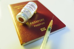Close up shot of a coronavirus vaccine bottle and a syringe with a Red colored Turkey’s passport as a vaccine passport.
