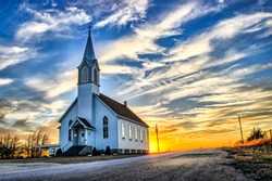 A Lone Wooden Church at Dusk with Sunset Clouds in Kansas American Midwest Prairie