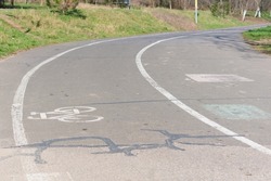 White bicycle sign on an asphalt bike lane in a city park. Track. Asphalt. Cyclist. Lane. Healthy. Line. Symbol. Outdoor. Travel. Ride. Safety. Way. Health. Biking. Urban