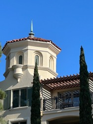 Octagonal cupola of a Tuscan style villa with a blue sky in the background.