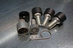 Wheel locks set against steel background.  Set of anti-theft bolts for a car on a steel background.