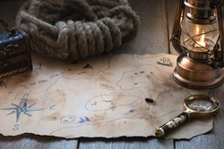 Exploration, adventure and treasure hunt background, vintage map, kerosene lamp, chest, magnifier on wooden table. Columbus day.