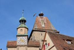 storks nest on a city wall tower in the medieval cty of Rothenburg on Tauber, Franconia, Germany